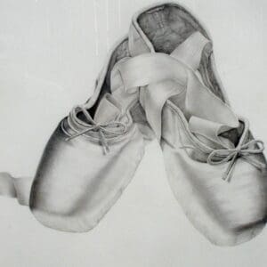 A pair of ballet shoes with a ribbon around the ankles.